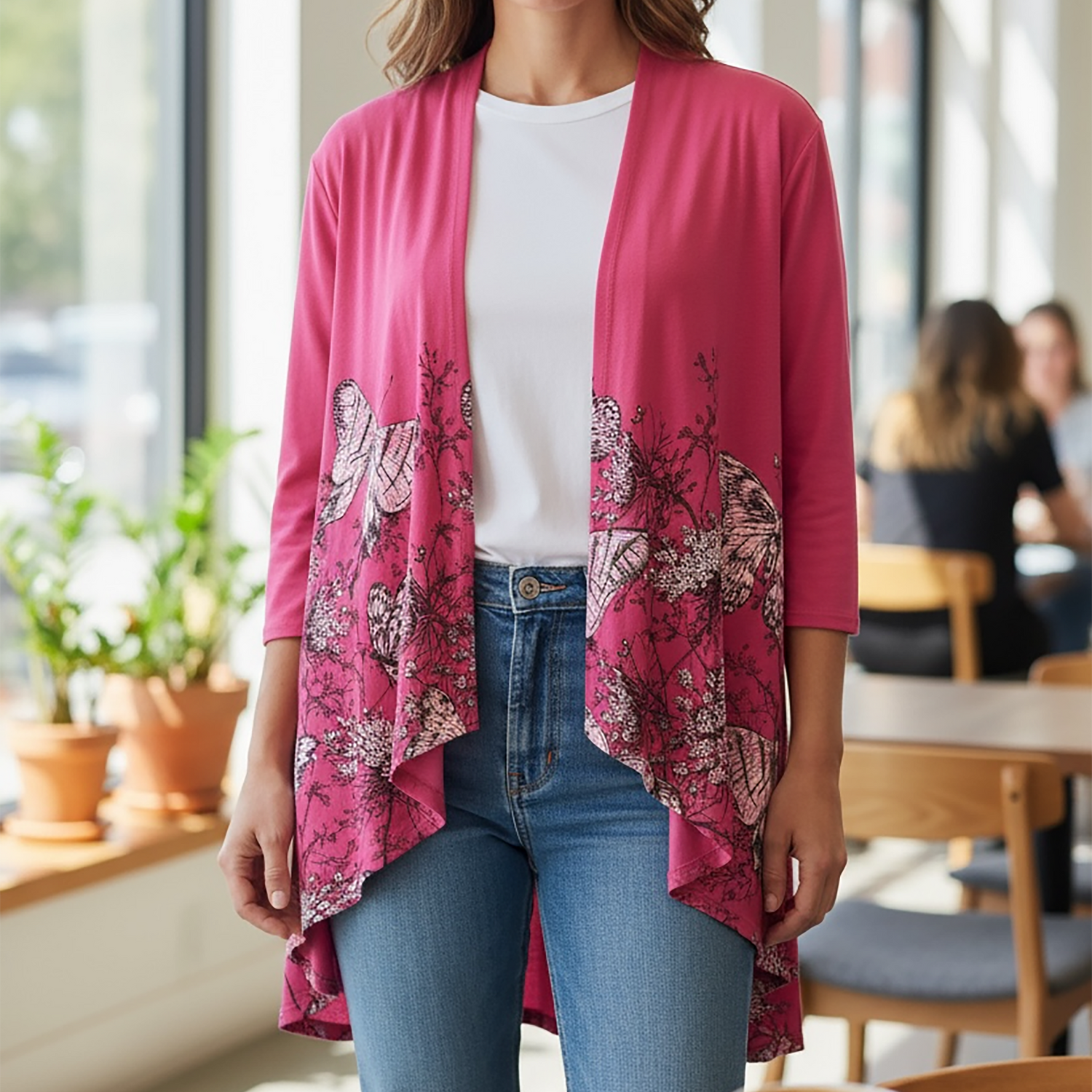Woman wearing a pink patterned cardigan in a cafe setting